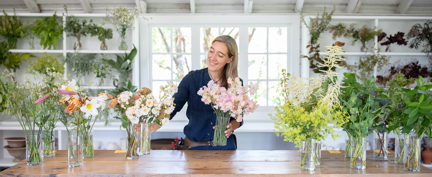 Erin Benzakein surrounded by vessels filled with blooms and foliage