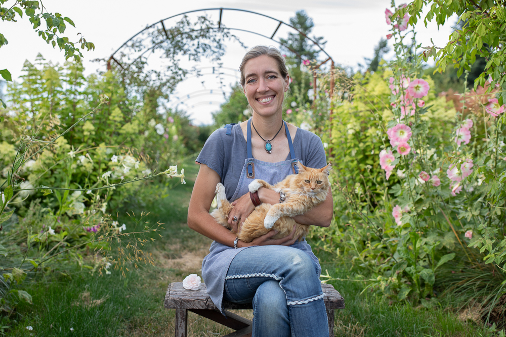 Erin Benzakein holding farm cat Timmy in the cutting garden at Floret