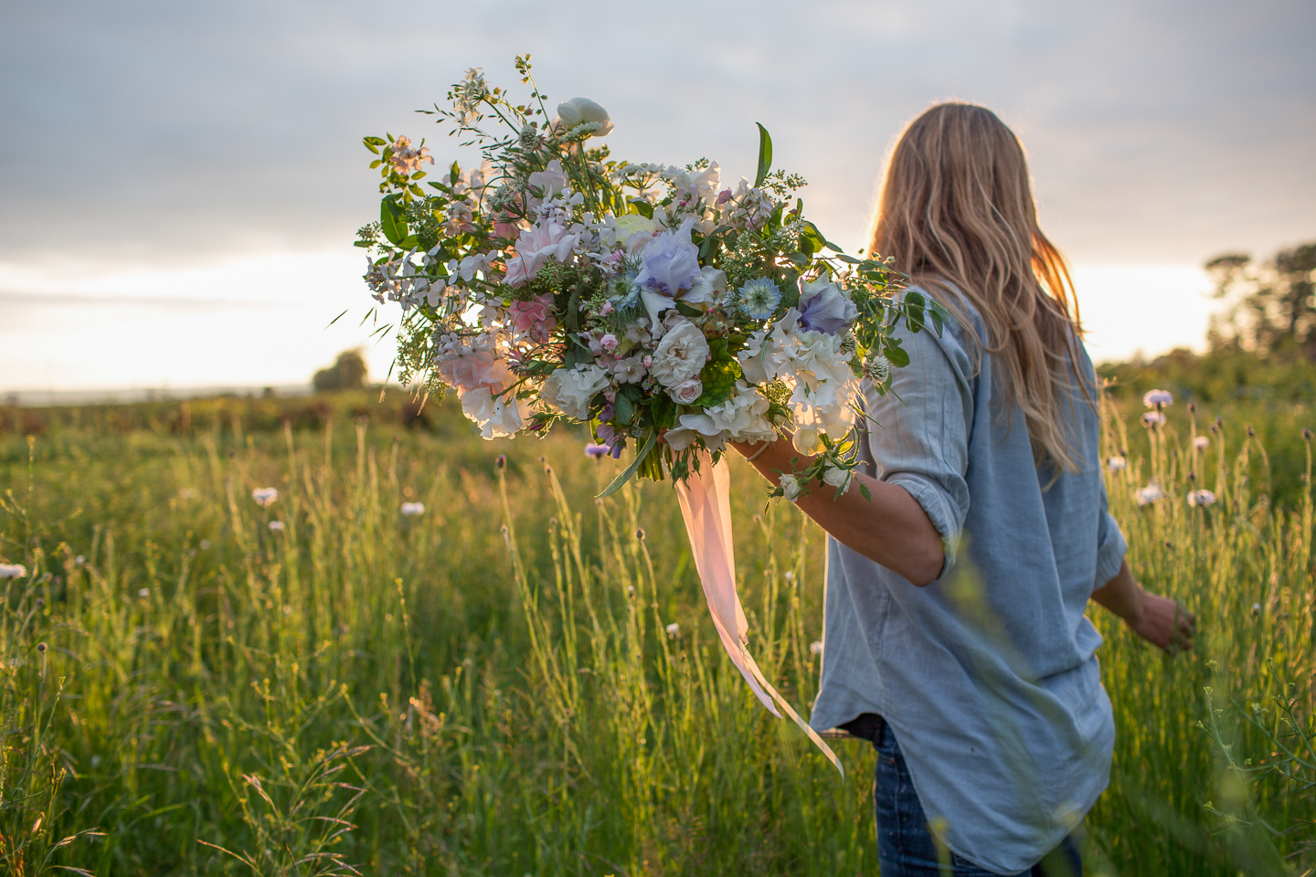 Erin Benzakein holding a bouquet in the field at Floret