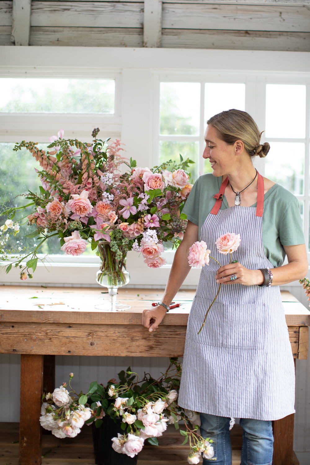 Erin Benzakein in the studio at Floret with a lush seasonal arrangement she created